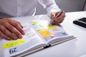 Businessman Writing Schedule In Diary